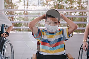 Asian special child on wheelchair wearing a protection mask