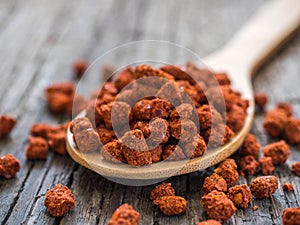 Asian spices. Dry adjika in spoon on wooden background. Closeup