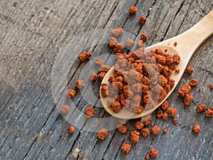 Asian spices. Dry adjika in spoon on wooden background. Closeup