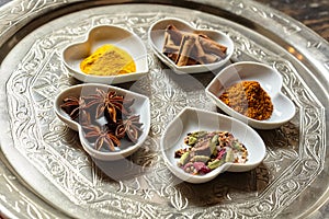 Asian spices in heart shaped dishes over plate