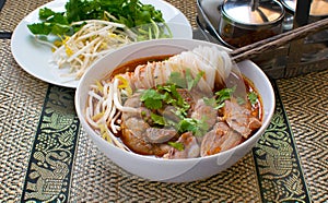 Asian spicy noodle soup with chopstick hold on noodle with pork