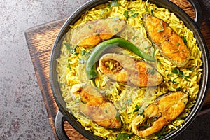 Asian spicy pilaf with fish steaks close-up in a frying pan. horizontal top view