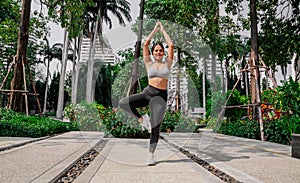 Asian sport girl doing stretching, yoga fitness and plank exercise outside. Fit young thai woman doing training workout