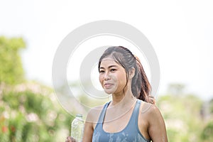 Asian sportswoman cools down by pouring fresh water, female fitness pouring water over her perfect body