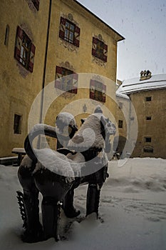 Asian statue in the courtyard of the castle of bruneck during a snowfall