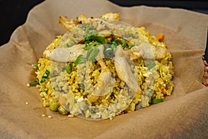 Asian street food Vietnam, fried rice with chicken and vegetables on a bamboo plate and craft paper.rice and fried chicken slices