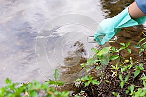 Asian student biology taking and testing sample of natural river water. Experts science women keep water for research analysis in photo