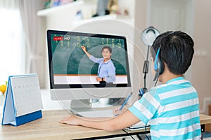 Asian  student boy video conference e-learning with teacher on computer in living room at home. E-learning ,online ,education and