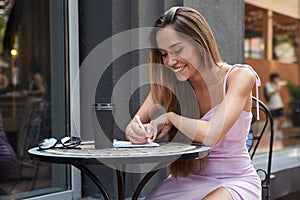 asian student girl with cup of coffee outside of cafe studying, doing homework