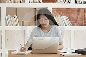 Asian student girl sitting at desk studying preparing for exams