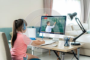 Asian  student girl video conference e-learning with teacher on computer in living room at home. E-learning ,online ,education and