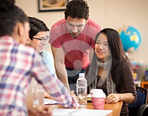 Asian student studying with colleagues in classroom