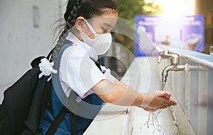 Asian student  washing hands at the outdoor wash basin in the school. Preventing Contagious diseases, Plague. Kids health,