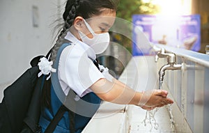 Asian student  washing hands at the outdoor wash basin in the school. Preventing Contagious diseases, Plague. Kids health, photo