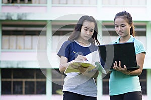 Asian students are using a taplet to check their grades.