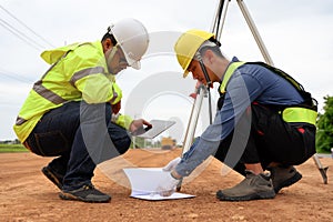 Asian surveyor engineer two people checking level of soil with Surveyor's Telescope equipment to measure leveling