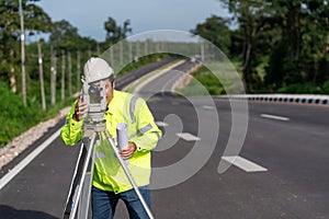 Asian surveyor engineer worker making measuring with theodolite on road works. survey engineer at road construction site, Surveyor