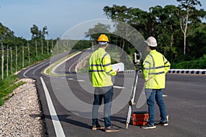 Asian surveyor engineers worker making measuring with theodolite instrument equipment during construction road works, Civil