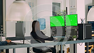 Asian system engineer using html script code and greenscreen on multiple monitors