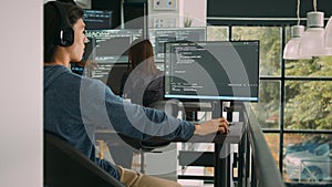 Asian system engineer working with html script on computer screen