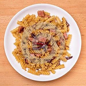 Asian tasty dish, stir-fried fusilli pasta with sliced bacon, ga