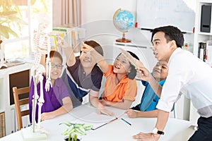 Asian teacher explains a human body structure to little pupil photo