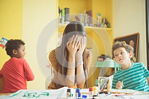 Asian teacher kindergarten hands closed both ears of her in an upset of failed to quell quoted naughty.
