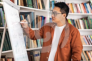 Asian Teacher Man Having Class Writing On Whiteboard In Classroom
