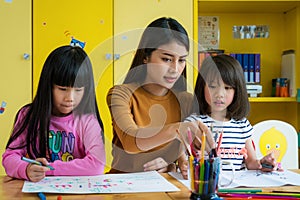 Asian teacher and preschool student in art class