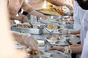 Asian teachers are distributing food to students,elementary school students are wait or queuing to receive free food,children
