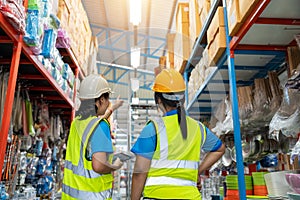 Asian teamwork of Warehouse workers taking package in the shelf in a large warehouse in a large warehouse. Working Woman Concept