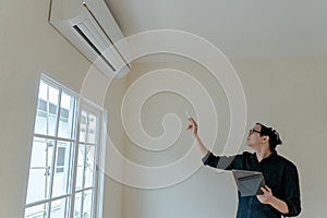 Asian Technician checking air conditioner