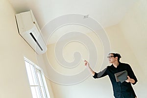 Asian Technician checking air conditioner