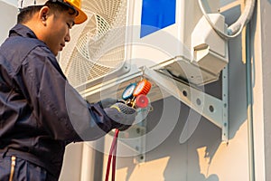 Asian technician is checking air conditioner, After-sales service concept