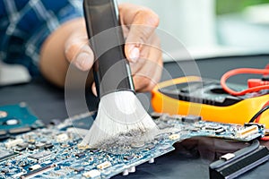 Asian technician repair and cleaning dirty micro circuit main board of smartphone electronic technology with brush, hardware,
