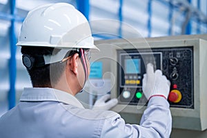 Asian technician worker wearing a safety suit and setting Shearing Machine in industrial factory, Safety first concept