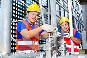 Asian Technicians or engineers working on valve