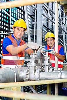 Asian Technicians or engineers working on valve