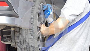 Asian technicians are repairing tire in garage.