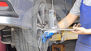 Asian technicians are repairing tire in garage.