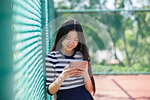 Asian teen age reading social media in computer tablet happiness