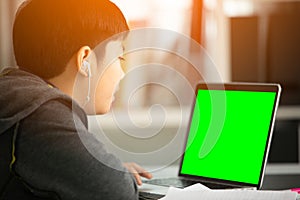 Asian teen boy using laptop computer at home,