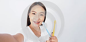 Asian teen facial with braces and toothbrush smiling to camera
