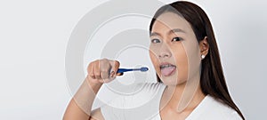 Asian teen facial with braces and toothbrush smiling to camera