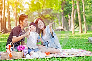 Asian teen family one kid happy holiday picnic moment in the park