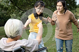 Asian teen granddaughter dissuade her family from a big fight,angry senior mother ,aggressive daughter arguing violently,abusing,