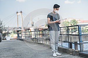 asian teen in protective mask using smartphone air