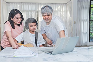 Asian teenage boy studying music, playing guitar online at home