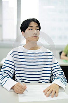 Asian teenage boy studying in a tuition class