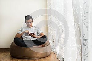 Asian teenage boy using a digital tablet